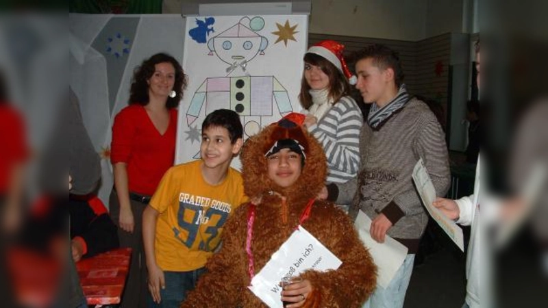 Mathematik einmal anders: Initiatorin Patricia Obermeier (l.) mit Schülern verschiedener Klassen und dem Weihnachtsbären vor der Station „Geoweihnachtsmann”. (Foto: bb)