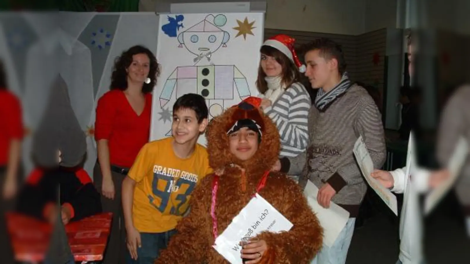 Mathematik einmal anders: Initiatorin Patricia Obermeier (l.) mit Schülern verschiedener Klassen und dem Weihnachtsbären vor der Station „Geoweihnachtsmann”. (Foto: bb)