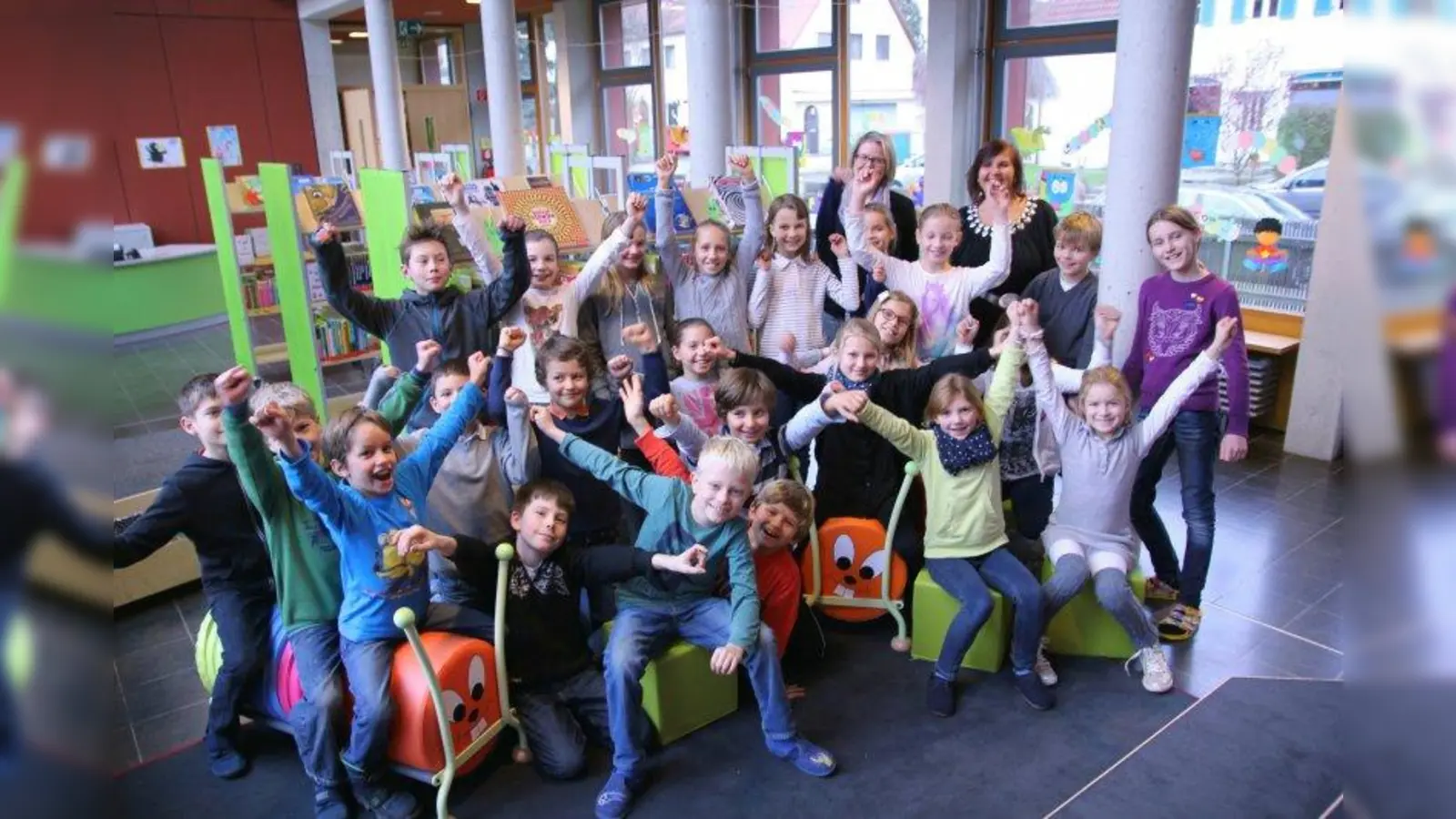 Farbenfroh und hell: Die Bücherei ist ein Rückzugsort zum Schmökern und Ausleihen geworden. Gemeindebibliothekarin Elke Naeve und Rektorin Angelika Nerz-Lidl (im Bild hinten, v.l.) mit Viertklässlern in der neuen Schulbücherei. (Foto: us)