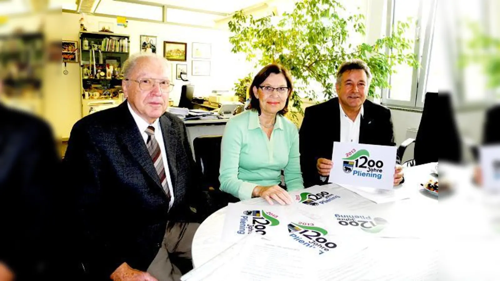 Ortschronist Willi Kneißl, Graphikerin Ursula Bauer und Bürgermeister Rittler (v. re.) haben jetzt das Logo für das Jubiläumsjahr vorgestellt.	 (Foto: Gabriele Heigl)