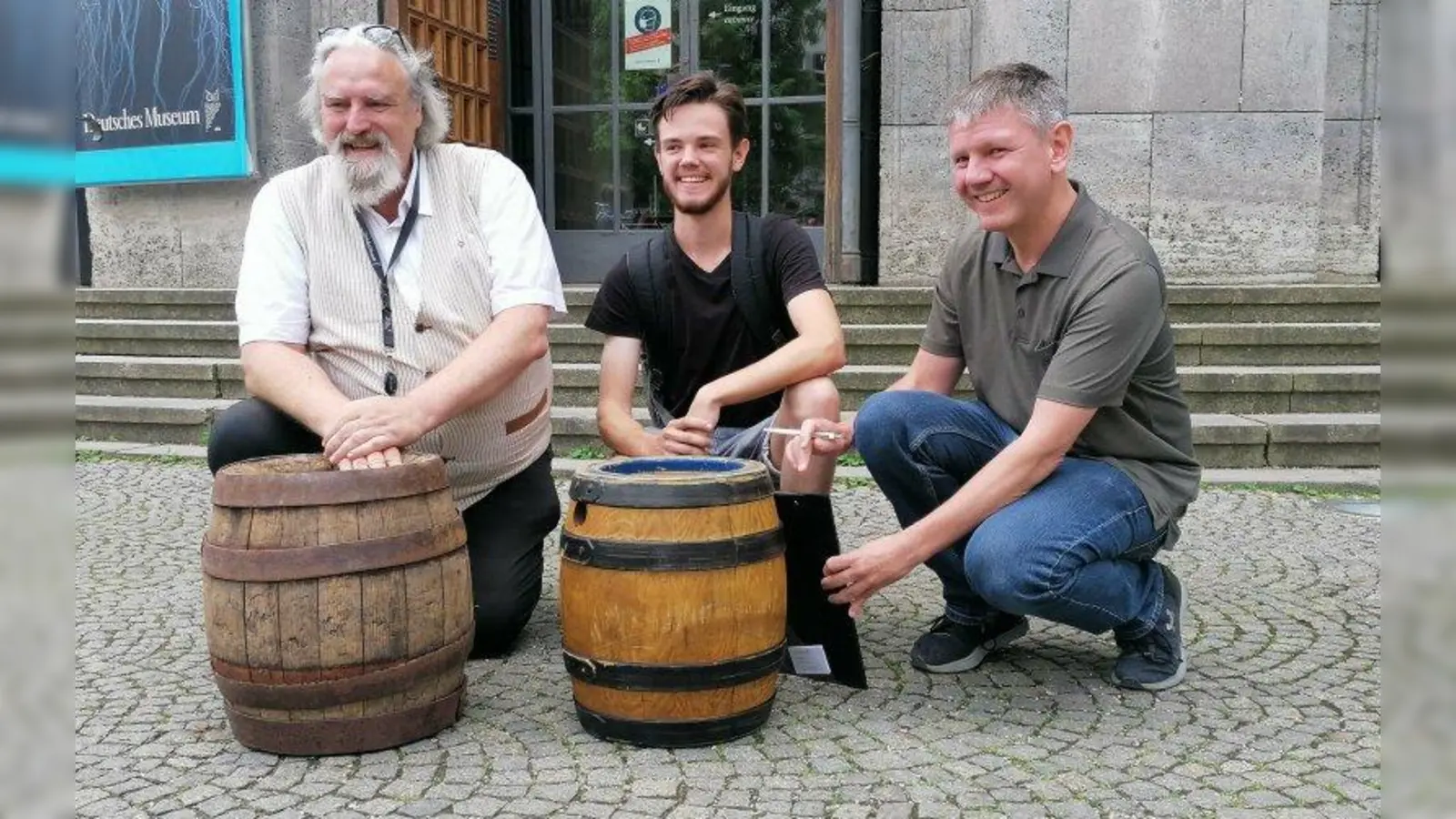 Daniel mit Karl Ravens (links) und Kurator Thomas Röber (rechts) vom Deutschen Museums mit dem alten Fass und dem neuen, noch vollen. (Foto: job)