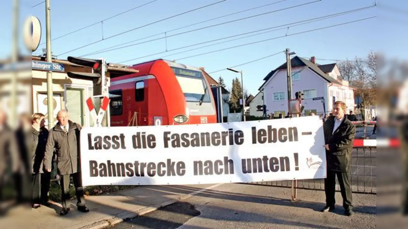 Mitglieder der Interessengemeinschaft Fasanerie aktiv demonstrierten vor der Bahnschranke gegen die geplante Straßenunterführung und forderten stattdessen eine Tieferlegung der Gleise. 	 (Foto: ws)