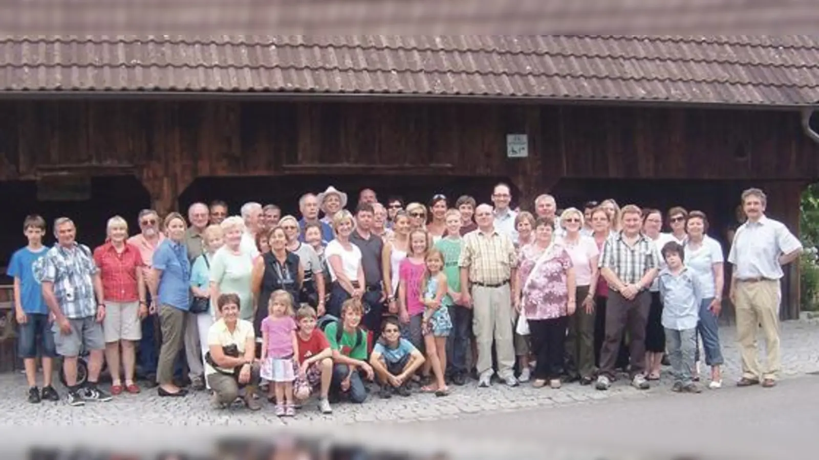 Besucher aus Haimhausen vor der historischen Weinkelter »Torkel« in Nonnenhorn lachen fürs Gruppenbild zufrieden in die Kamera.   (Foto: VA)