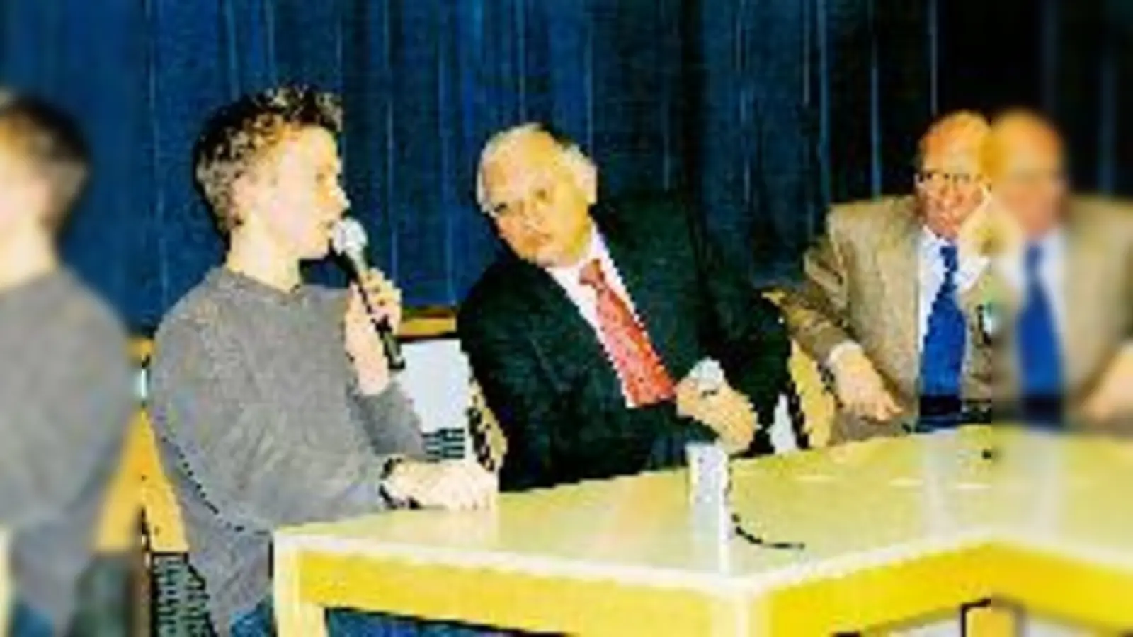 EU-Erweiterungskommissar Günter Verheugen (Mitte, rechts Franz Maget) stellte sich vergangene Woche den diversen Fragen der Schüler des Willi-Graf-Gymnasiums, hier Leon Hirth von der K 13 (li.).	 (Foto: ms)