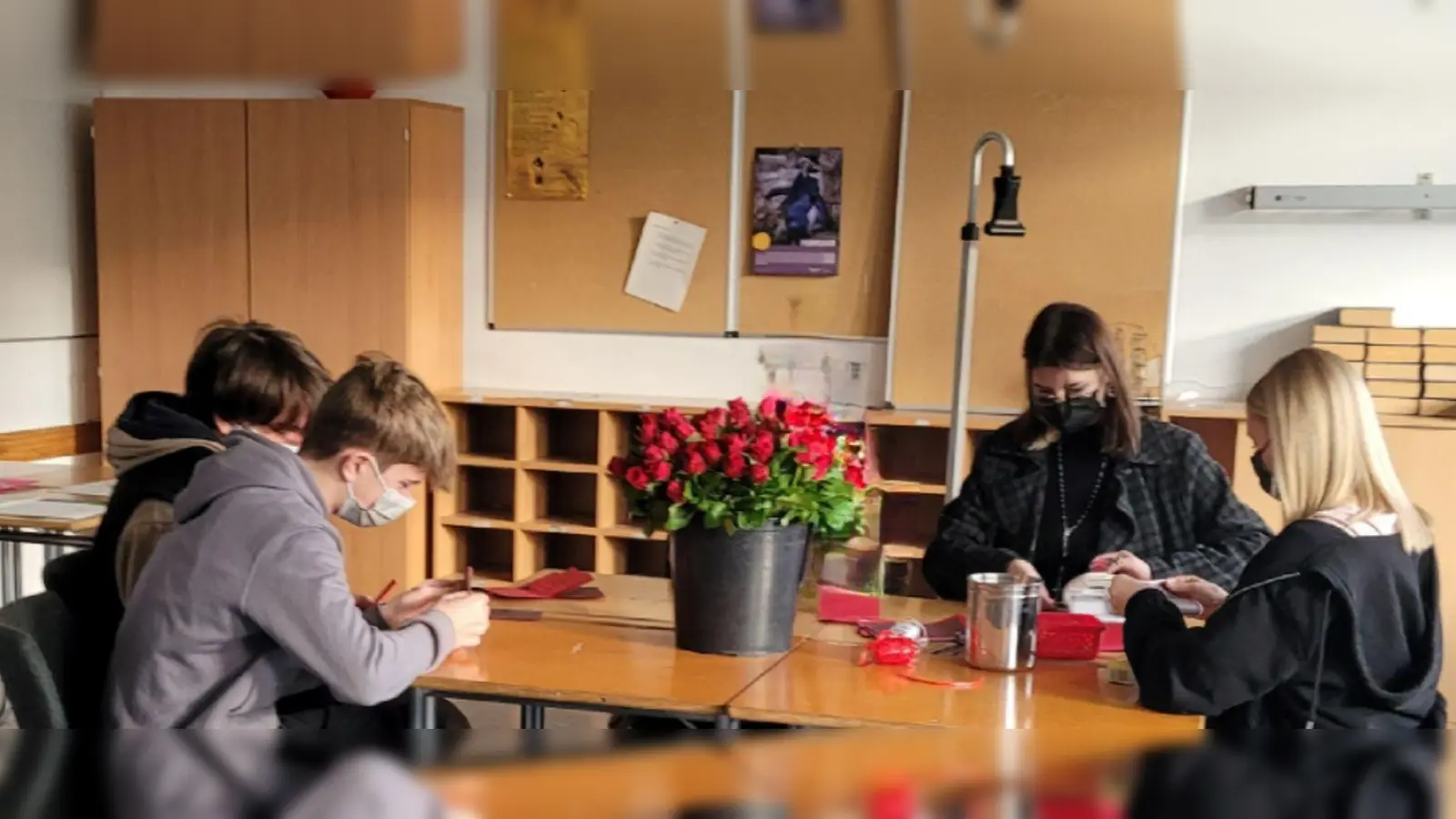 Rosen-Verschenk-Aktion in der Georg-Büchner-Realschule: Das Rosenverteilungsteam befestigte die Grußkarten an die Rosen, bevor sie an ihre Adressaten übergeben wurden. (Foto: Georg-Büchner-Realschule )