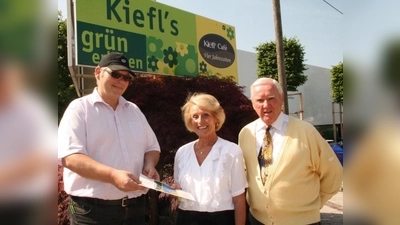 Für das Ehepaar Annemarie und Peter Silbernagl (re.) aus München geht es zu einem Wellness-Wochenende nach Kärnten. Wolfgang Kiefl (l) überreichte den glücklichen Gewinnern der Kiefl-Verlosung den Hotelgutschein. (Foto: US)