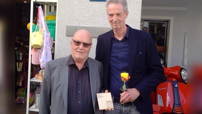 Familienmitglied Paul Maria Wittmann (links) und Initiator Thomas Hennet mit dem Erinnerungszeichen für Georg Pöltl, das nun in der Ismaninger Straße 77 hängt. (Foto: bas)