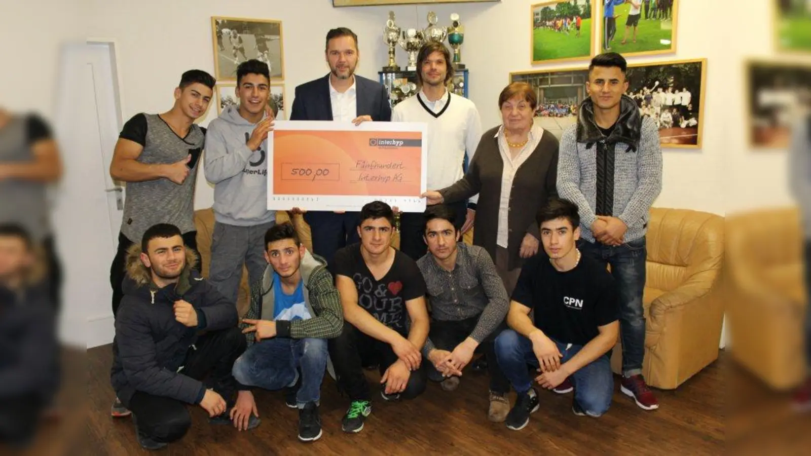 Scheckübergabe: Interhyp-Mitarbeiter Sascha Hönig (stehend 3.v.l.) und die beiden CPN-Vorstandsmitglieder Christian Hrdina (stehend 3.v.r.) und Anne Weiß zusammen mit Jugendlichen aus dem Clean Projekt Neuhausen. (Foto: sb)