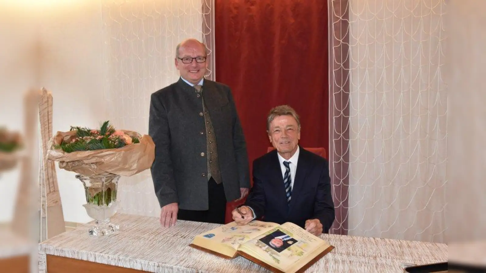 Dr. Lorenz Friedrich (rechts) trägt sich ins Goldene Buch von Berg ein, neben ihm steht Bürgermeister Rupert Monn. (Foto: Hauck)