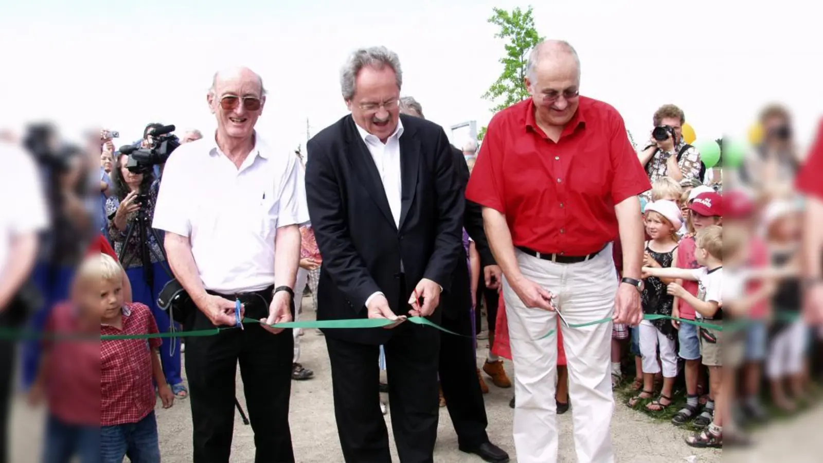 Mit dem Durchtrennen eines Bandes eröffnete Oberbürgermeister Christian Ude gemeinsam mit Werner Dilg (links) und Thomas Hampel (rechts) offiziell den Aubinger Geschichtspfad. (Foto: Eva Schraft)