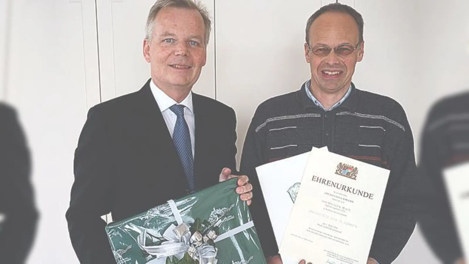 Wolfgang Reger (rechts) wurde für sein 25. Dienstjubiläum von Bürgermeister Jan Neusiedel (links) eine Ehrenurkunde überreicht. 	 (Foto: Gemeinde Grünwald)