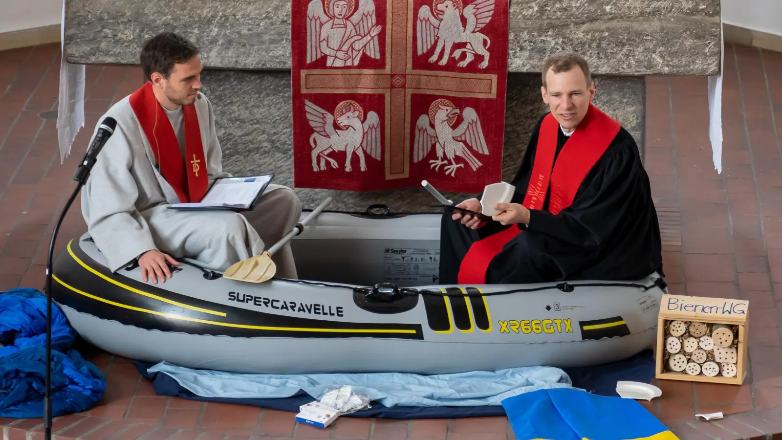 Diakon Alexander Irmer (links) und Pfarrer Michael Hinderer begaben sich bei der Konfirmationspredigt in ein Schlauchboot vor dem Altar. (Foto: Moritz Heigl)