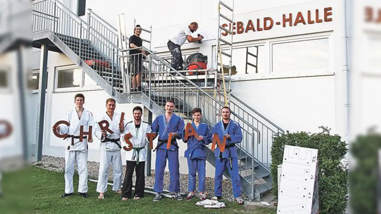 Die Judo-Vorstände Jaud und Larasser beim Montieren des Schriftzuges Christian Sebald Halle. 	 (Foto: Peter Franz)