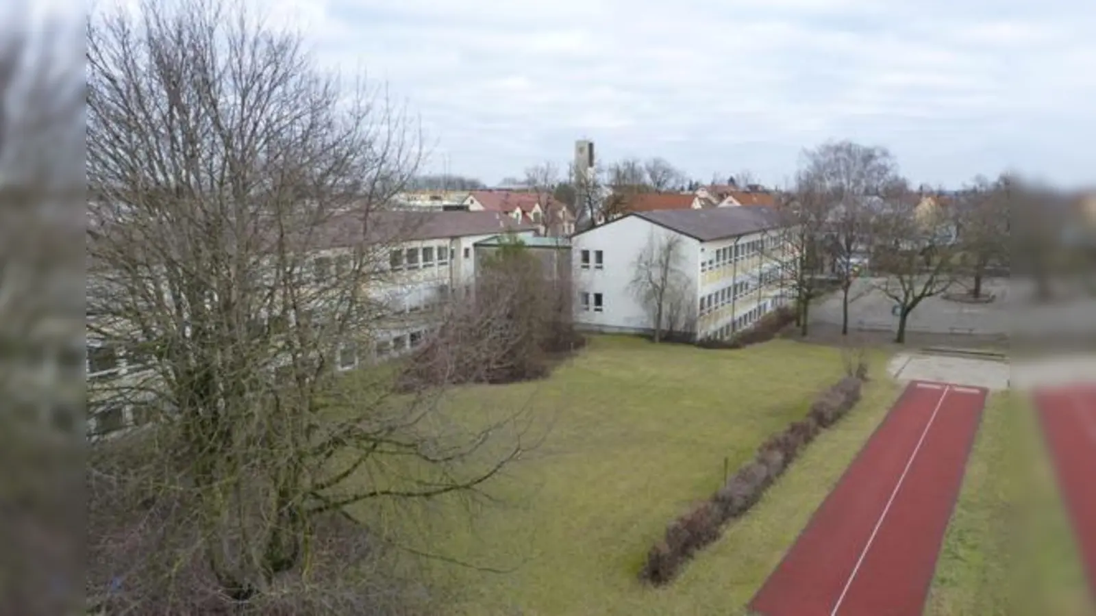 Hier wird der dreigliedrige Neubau der Grundschule entstehen: rechts neben den Büschen der Fachraumtrakt, hinterm Hartplatz das Gebäude für die Ganztagesbetreuung, links der Haupttrakt. 	 (Foto: bb)