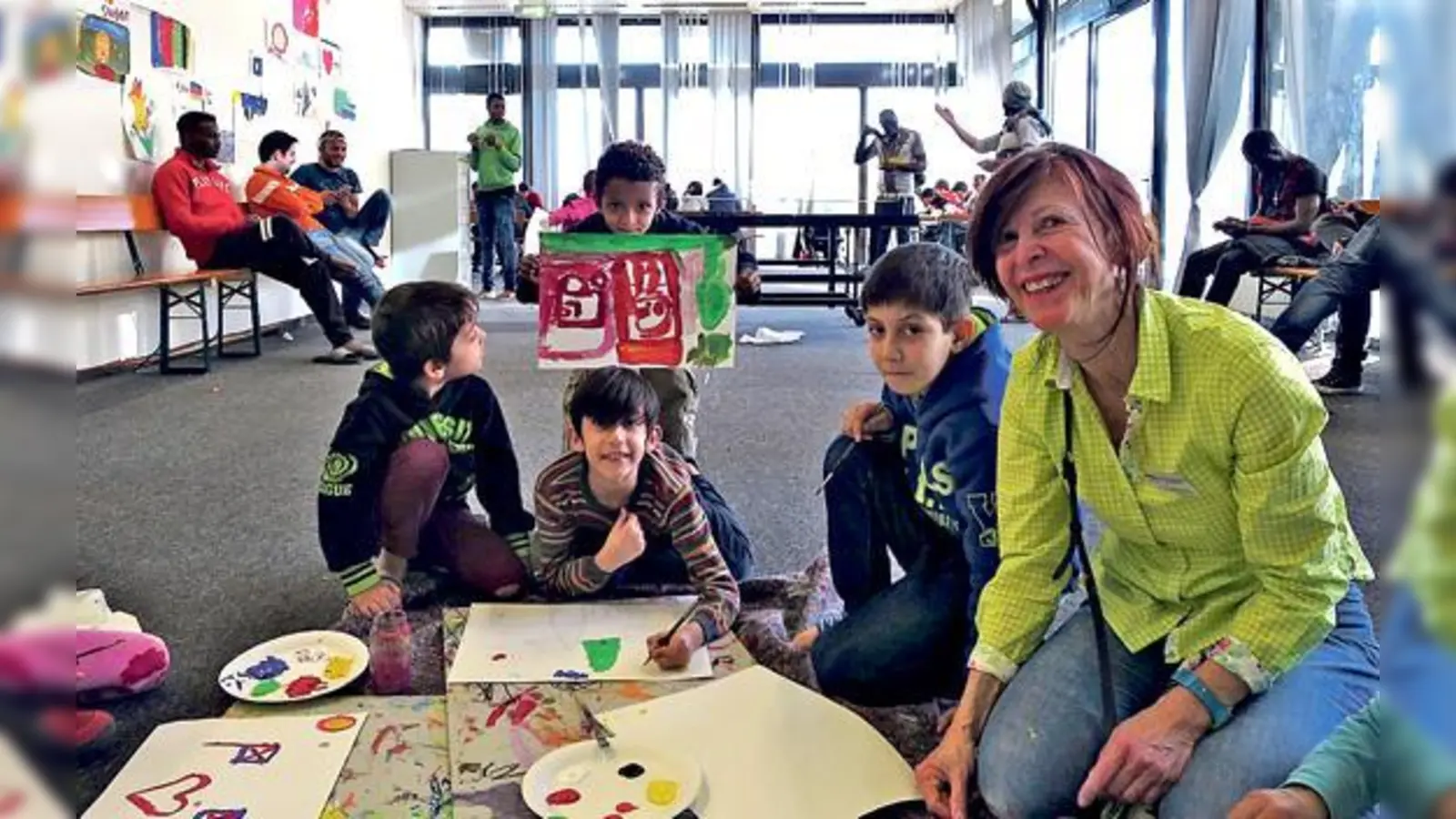 Ein Lächeln auf den Gesichtern der Kinder  mehr wünscht sich Cornelia Groh (re.) gar nicht. Und das erhält sie bei ihren wöchentlichen Malkursen in der Flüchtlingsunterkunft an der Richard-Strauss-Straße. 	 (Foto: privat)