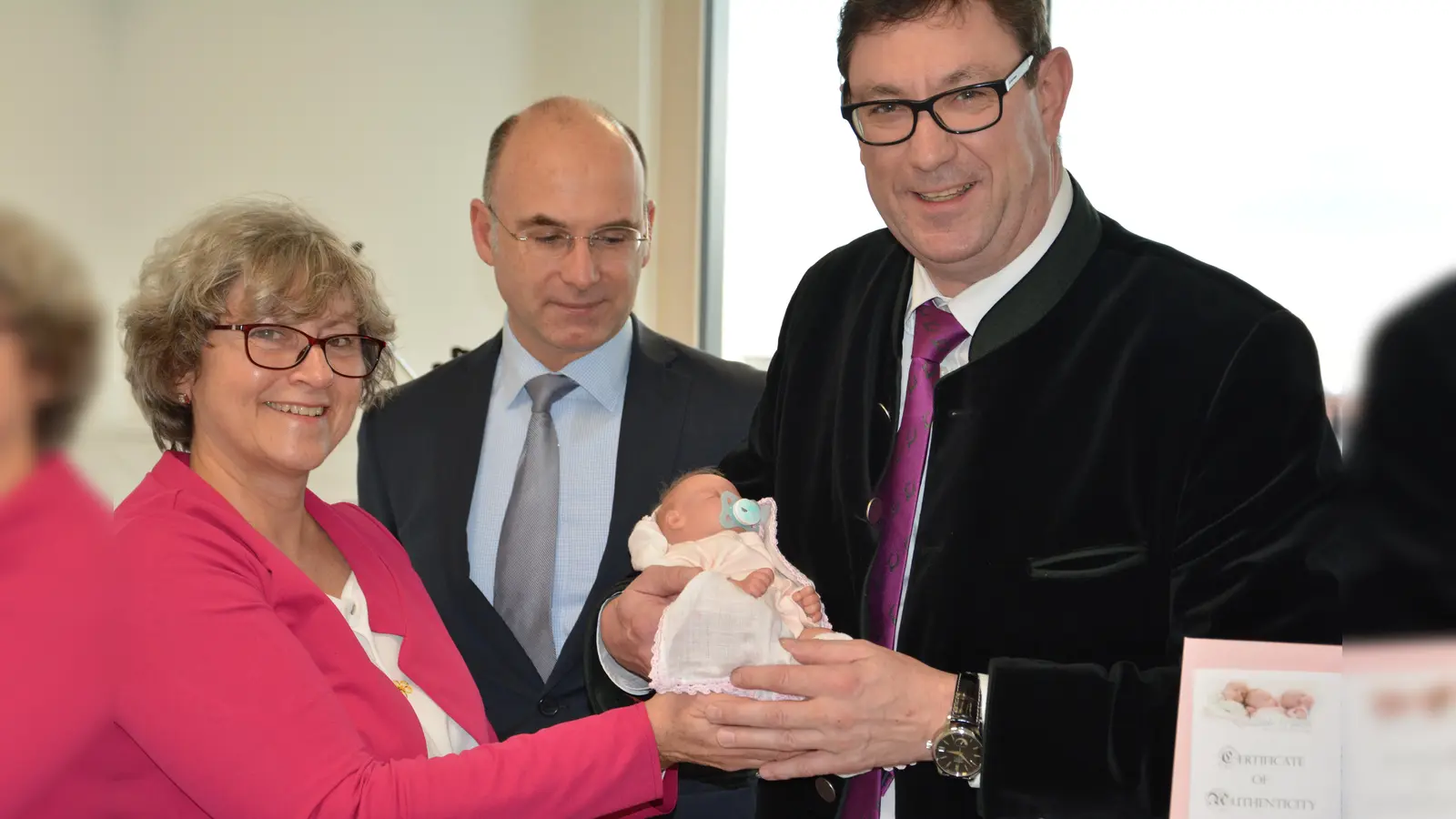 Barbara Mitschdörfer, Dr. Dirk Last und Landrat Martin Bayerstorfer (von links) mit der Frühchenpuppe. (Foto: LRA Erding)