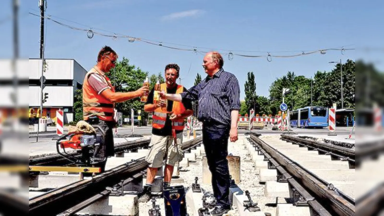 Mit Apfelschorle stieß Andreas Nagel (r.) mit Bauarbeitern auf das erste Gleisstück der Neubaustrecke nach St. Emmeram an. 	 (Foto: Aktion Fahrgäste)