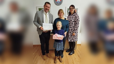 Die siebenjährige Hanna Pache aus Feldgeding erhielt von Bürgermeister Robert Axtner ein Geschenk.. (Foto: red)