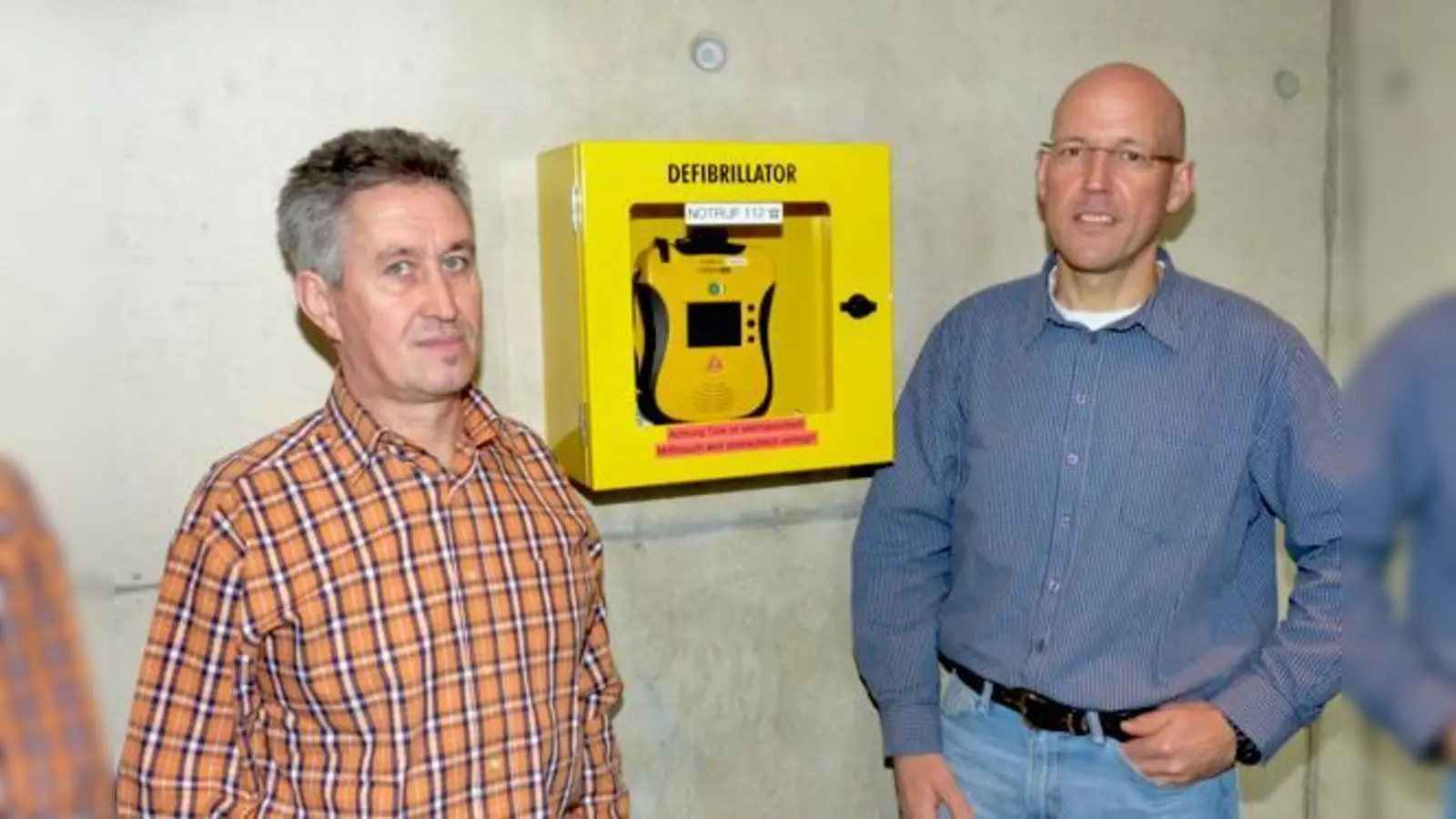 Georg Schneider (li.) und Hermann Maurer präsentieren den AED im Foyer des Rathauses.	 (Foto: bb)