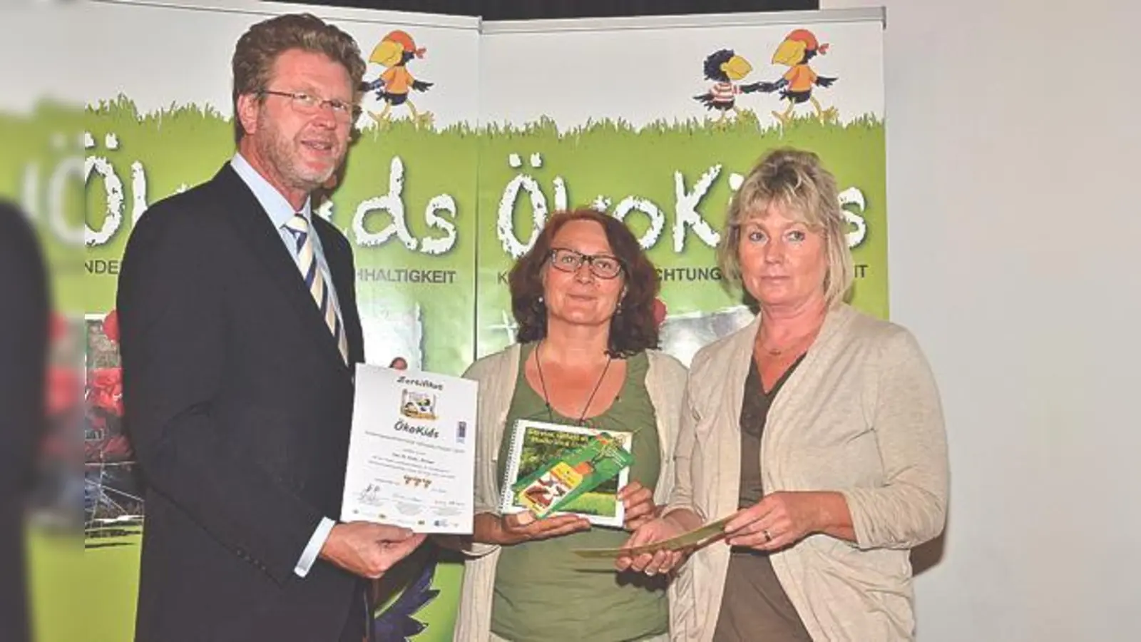 Umweltminister Huber überreicht die Urkunde an Monika Mousis und die Leiterin des Kindergartens, Karin Wecker (rechts).	 (Foto: VA)