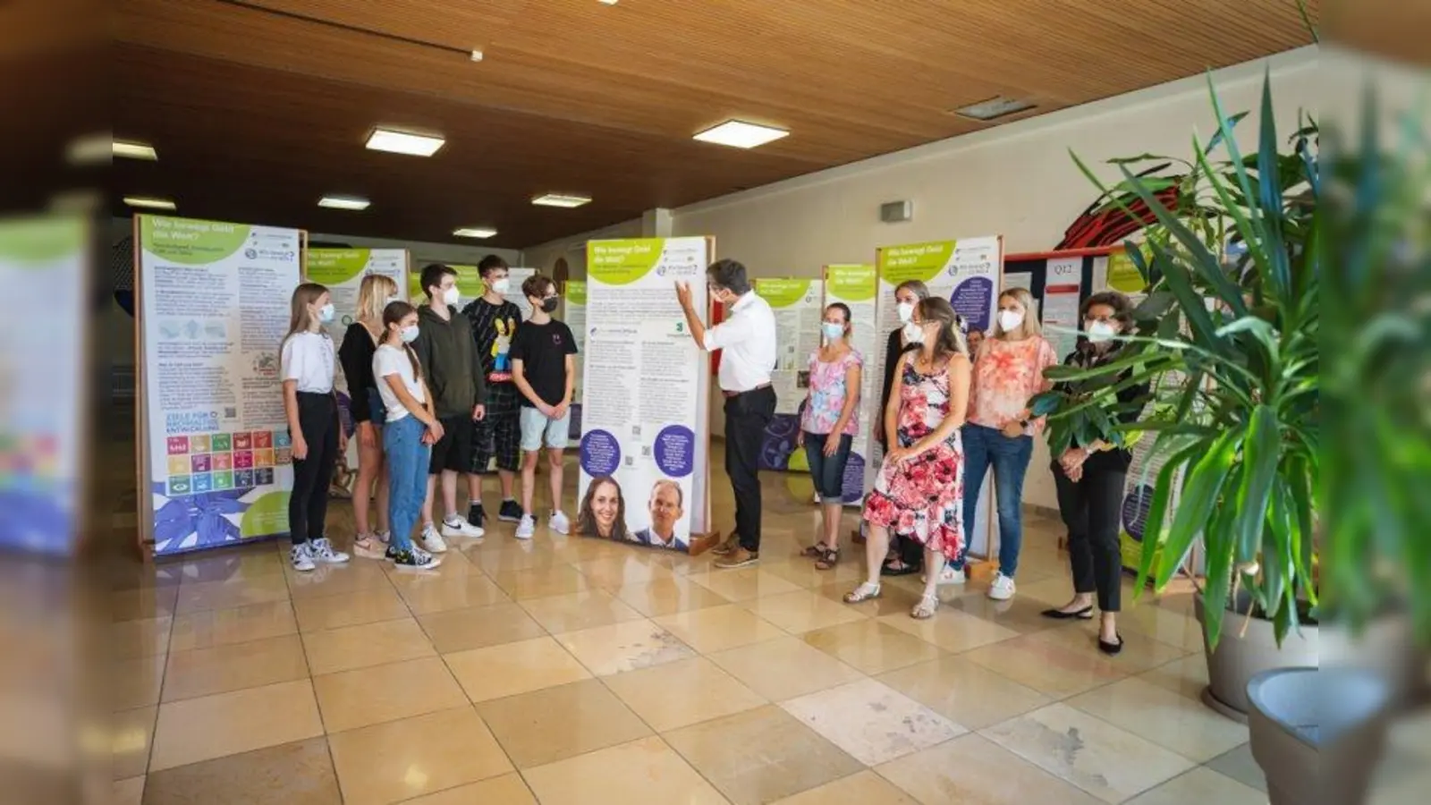 Eröffnung der Wanderausstellung „Wie bewegt Geld die Welt?”: Die Ausstellung zum Thema „Nachhaltige Finanzen” ist derzeit im Gymnasium Weilheim zu sehen (von rechts): Schulleiterin Beate Sitek, Heidi Geisler, Floriane Reichenberg und Angelika Schwan der Greensurance Stiftung, Fachbereichsleiterin Karin Ontiveros, Jan Wolthuis und Schüler des Gymnasiums. (Foto: Greensurance Stiftung)