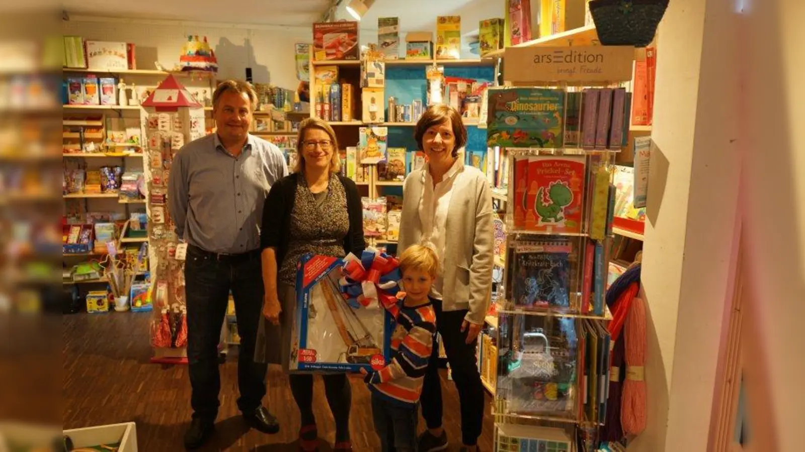 Der kleine Leopold (Mitte) freut sich über seinen neuen Kran. Bei der Preisübergabe v. li.: Ulrich Beigel, Vorstand Cityinitiative, Nicola Eggendorfer-Schropp (Kleines Spielhaus) und Victoria Lettl, Vorstand Cityinitiative. (Foto: City Initiative)