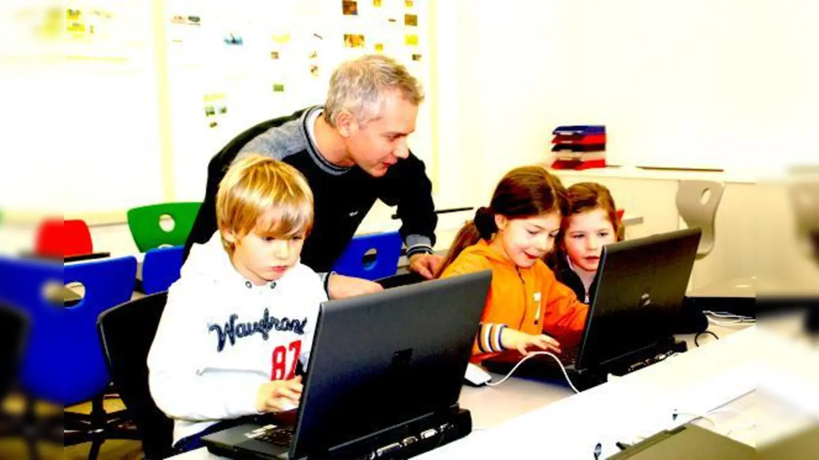 Bestens ausgerüstet ist der Computerraum der Martin-Kneidl-Schule. Systemadministrator Philipp Wynne erklärt Kindern, wie man am PC arbeitet. 	 (Foto: hol)