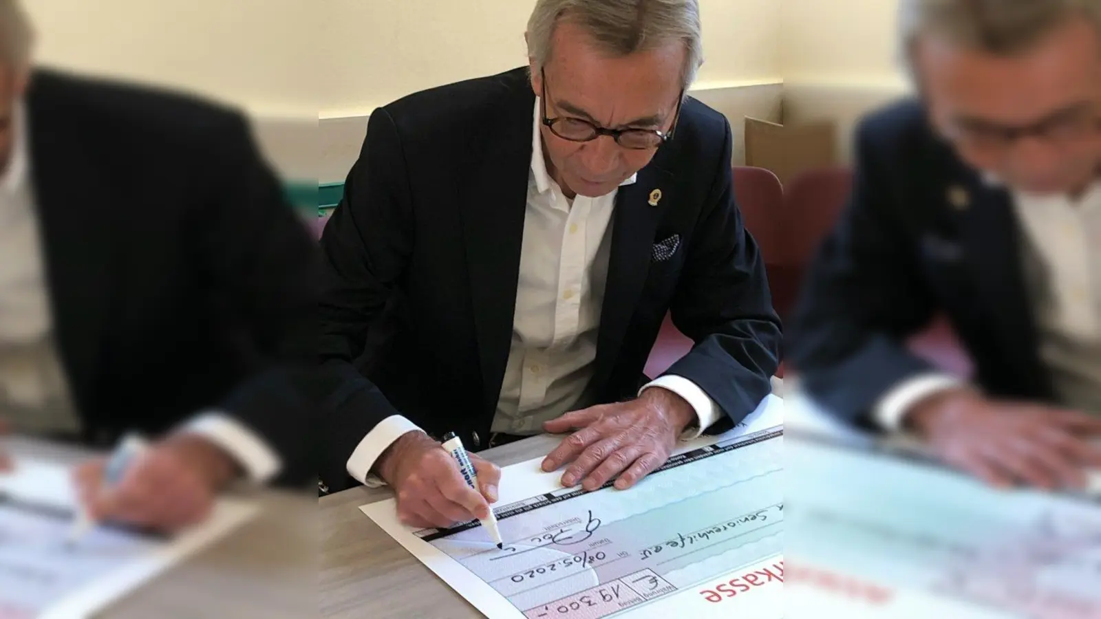Zonen-Chairman Gerhard Potuschek unterschreibt für die 18 beteiligten Münchner Lions Clubs einen Spendenscheck über 19.300 Euro. (Foto: Helmut Winkler)