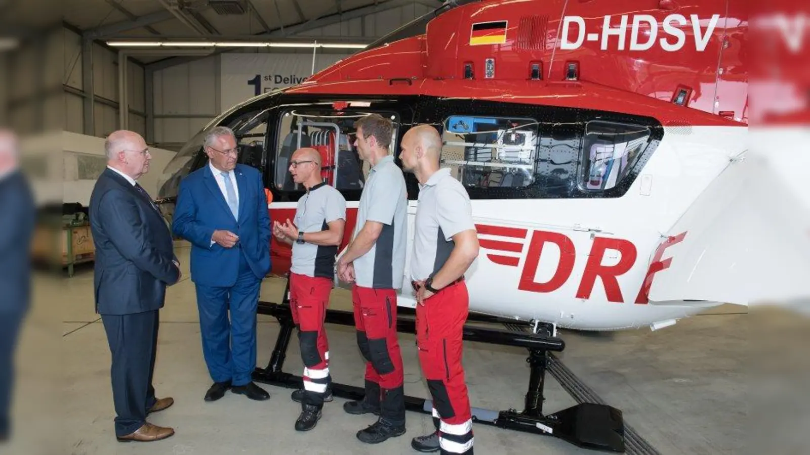 Bayerns Innenminister Joachim Herrmann (2. von links) und Dr. Peter Huber (links), Vorstand der DRF Luftrettung, im Gespräch mit Hubschrauberpiloten der DRF Luftrettung. (Foto: DRF Luftrettung LMU)