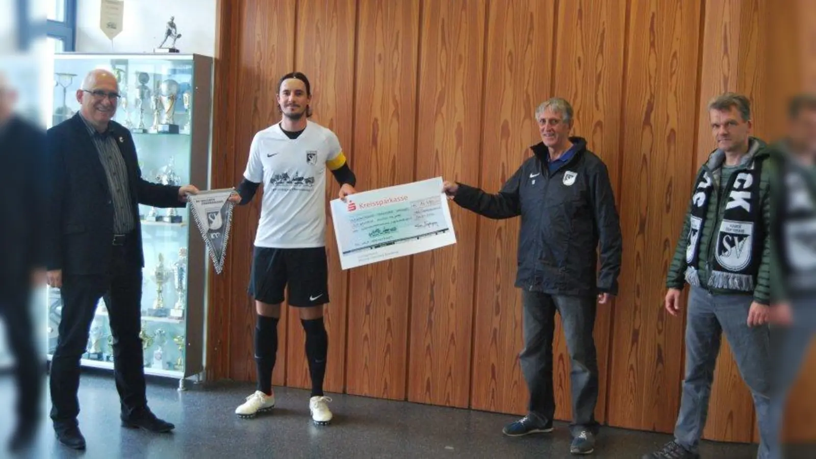 Übergabe des Spendenschecks an den SV Waldeck (von links): Frieder Vogelsgesang (Vorsitzender der Bürgervereinigung Obermenzing e.V.), Spielführer Kevin Klieber, Thomas Hasselwander (Schatzmeister der Bürgervereinigung) und Robert Steinhauser (Vorsitzender SV Waldeck). (Foto: Irina Vogelsgesang)