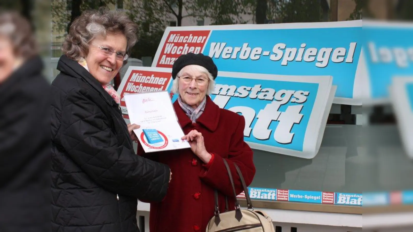 Marlene Froidl aus Pasing (rechts) hat ein Wochenende in einem Hotel in Südtirol gewonnen. „Darauf freue ich mich”, erzählt sie Anita Eska (Münchner Wochenanzeiger), die ihr den Gewinn überreicht, „früher war ich mit den Kindern oft zum Klettern in Südtirol!”<br>„Ich gehe gerne in die kleinen Geschäfte in meinem Viertel, wo ich alles in der Nähe habe”, so Froidl, „ich hole mein Brot immer beim Bäcker, das schmeckt, und beim Markt kann ich selbst sehen, welche Waren frisch sind.” (Foto: job)