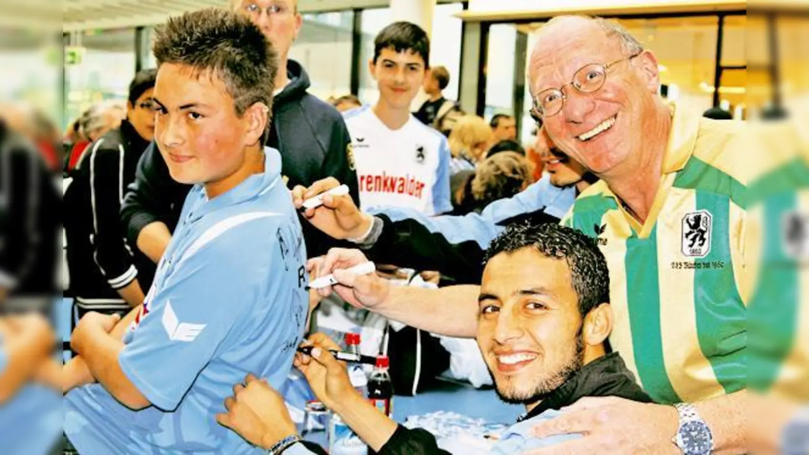 Radhouène Felhi und TSV-Vizepräsident Franz Maget signieren das Trikot von Löwen-Fan Stefan Buchschmid (15).	 (Foto: mst)