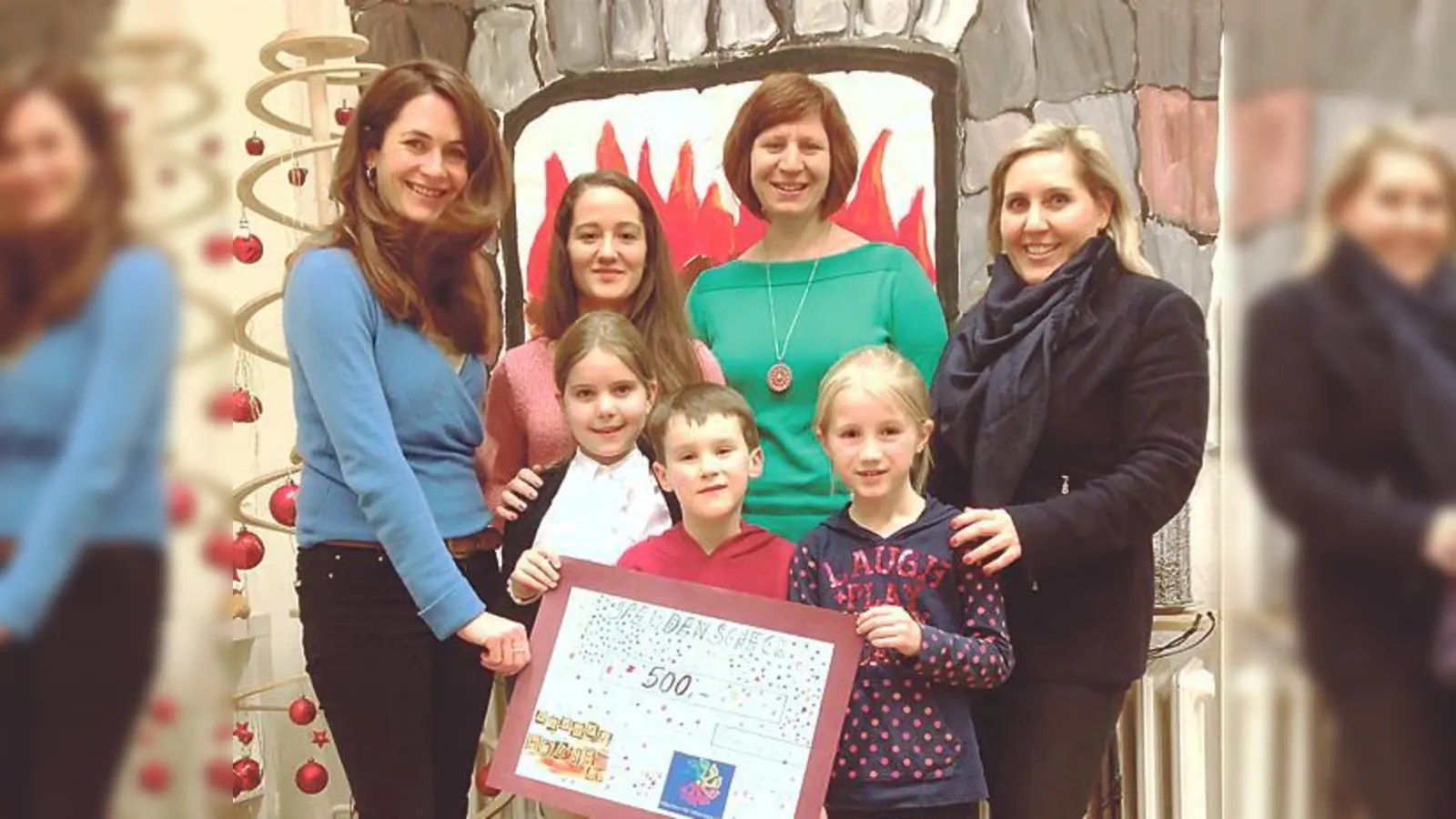 Natalie Schmid, Vorsitzende des Vereins Münchner für Münchner e.V., mit den Erzieherinnen Sarah Grootz und Nicki Fischer sowie Claudia Reischel, Elternvorstand von KinderHOUSE (hinten v. li.) und fleißigen Helfern bei der Scheckübergabe.  (F.: priv)