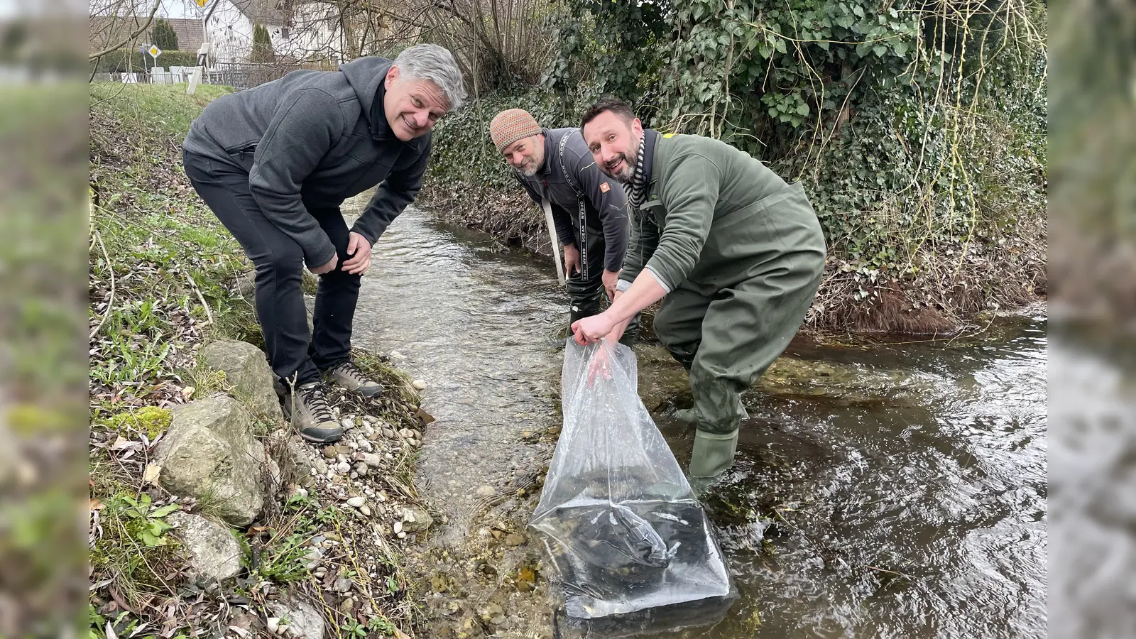Gemeinsam mit Bürgermeister Stefan Joachimsthaler (links) entließen Roland Meyer (Mitte) und Christoph Brzoska die Forellen in den Starzelbach. (Foto: red)