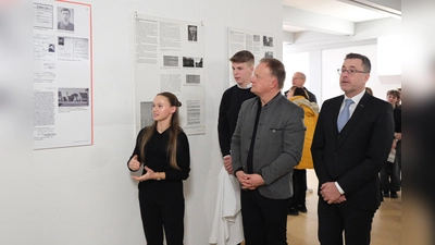 Die Schülerin Annika Kuhwald und der Schüler Simon Martl enthüllen nach der Gedenkveranstaltung im Beisein von Landrat Robert Niedergesäß und Schulleiter Peter Popp eine Gedenktafel für Arnold Wachtel.  (Foto: LRA Ebersberg)