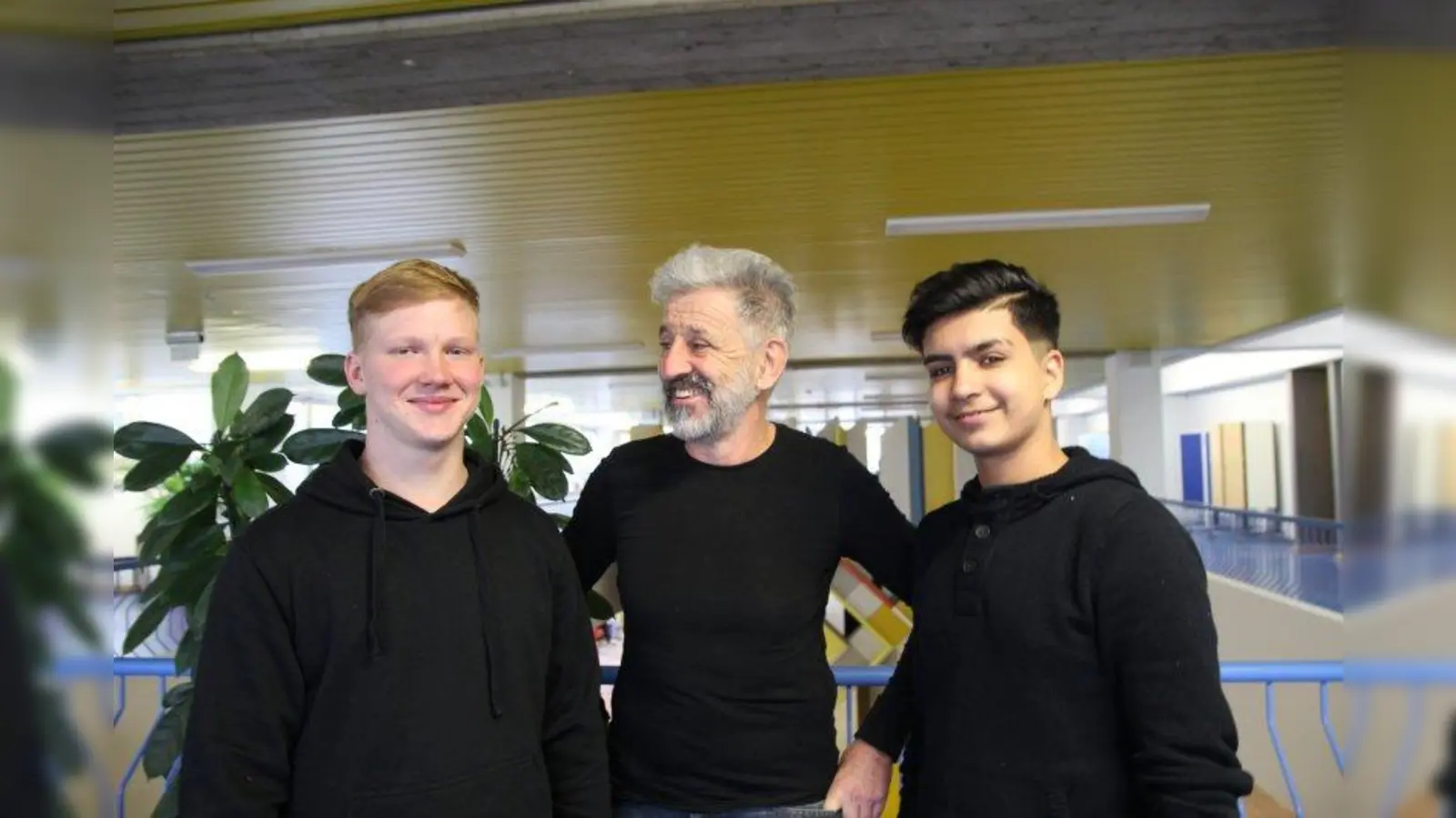 „Ein Jobmentor muss die Realität im Auge behalten. Das ist nicht immer einfach. Aber wir sind voll in der Schule integriert und erhalten hohe Wertschätzung!” Gottfried von Aulock mit Daniel und Sani aus der neunten Klasse im Lichthof der Mittelschule an der Peslmüllerstraße. (Foto: us)