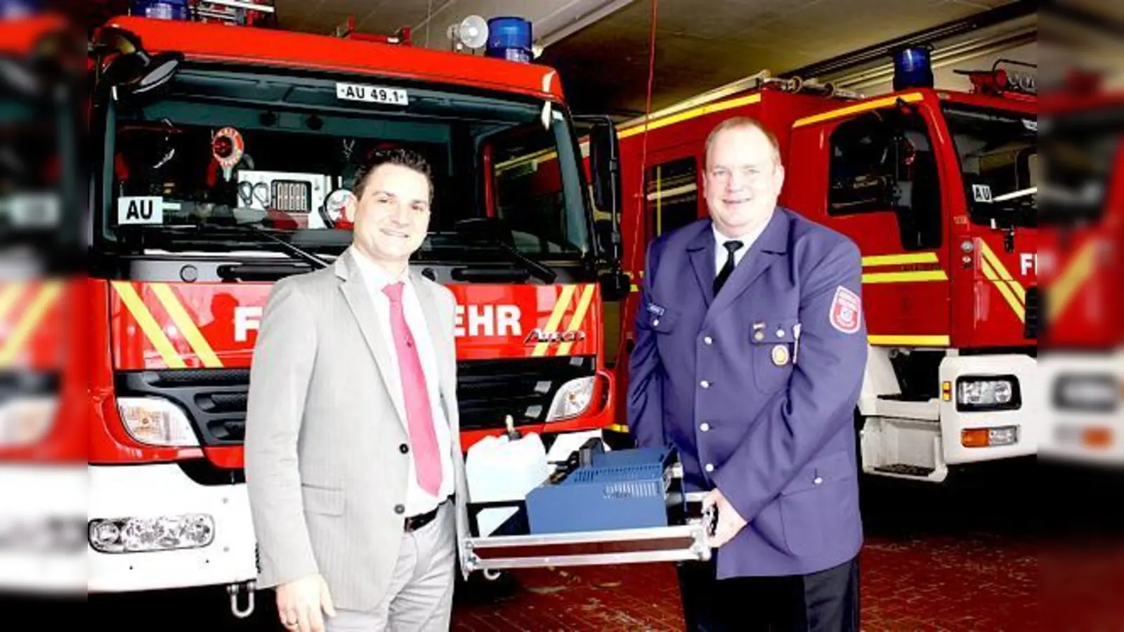 Roger Tosetto und Helmut Meßmann bei der Übergabe der Nebelmaschine an die FF Aubing.	 (Foto: cr)