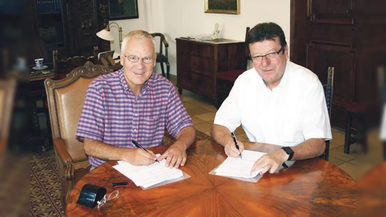 Die Bürgermeister Walter Brilmayer und Alois Hofstetter bei der Signierung des neuen Vertrags.	 (Foto: Stadt Ebersberg)