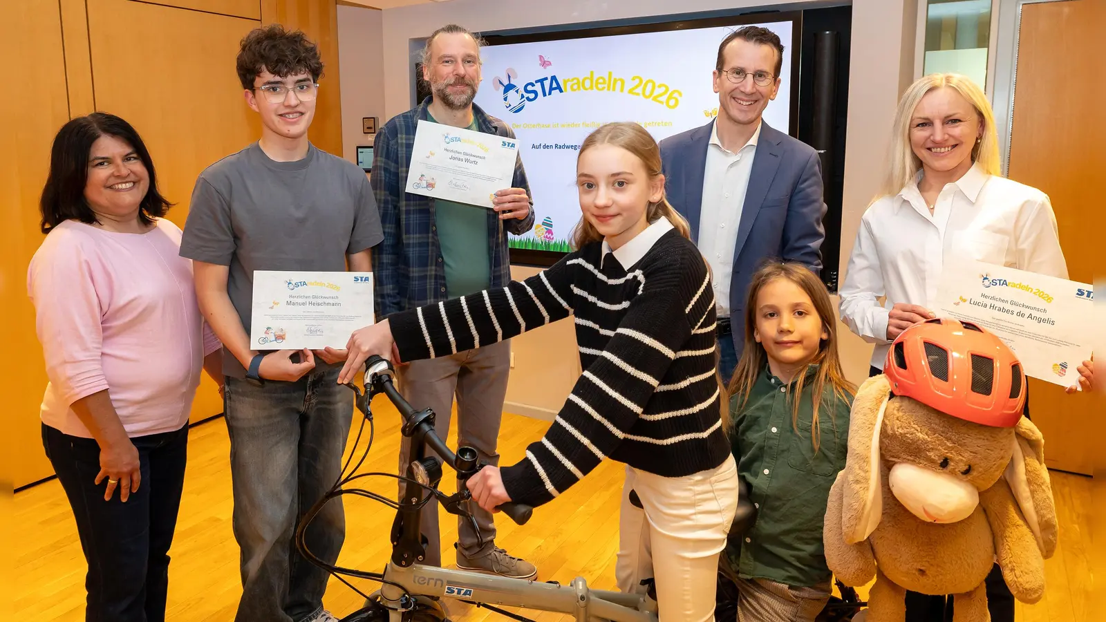 Freuen sich über die Gewinne (v.l.): Andrea Heischmann, Manuel Heischmann, Jonas Wurtz, Charlotte Hrabe de Angelis, Landrat Stefan Frey, Adam Stelle, Lucia Hrabe de Angelis und das Radverkehrs-Maskottchen Radl-Rudi. (Foto: Landratsamt Starnberg)