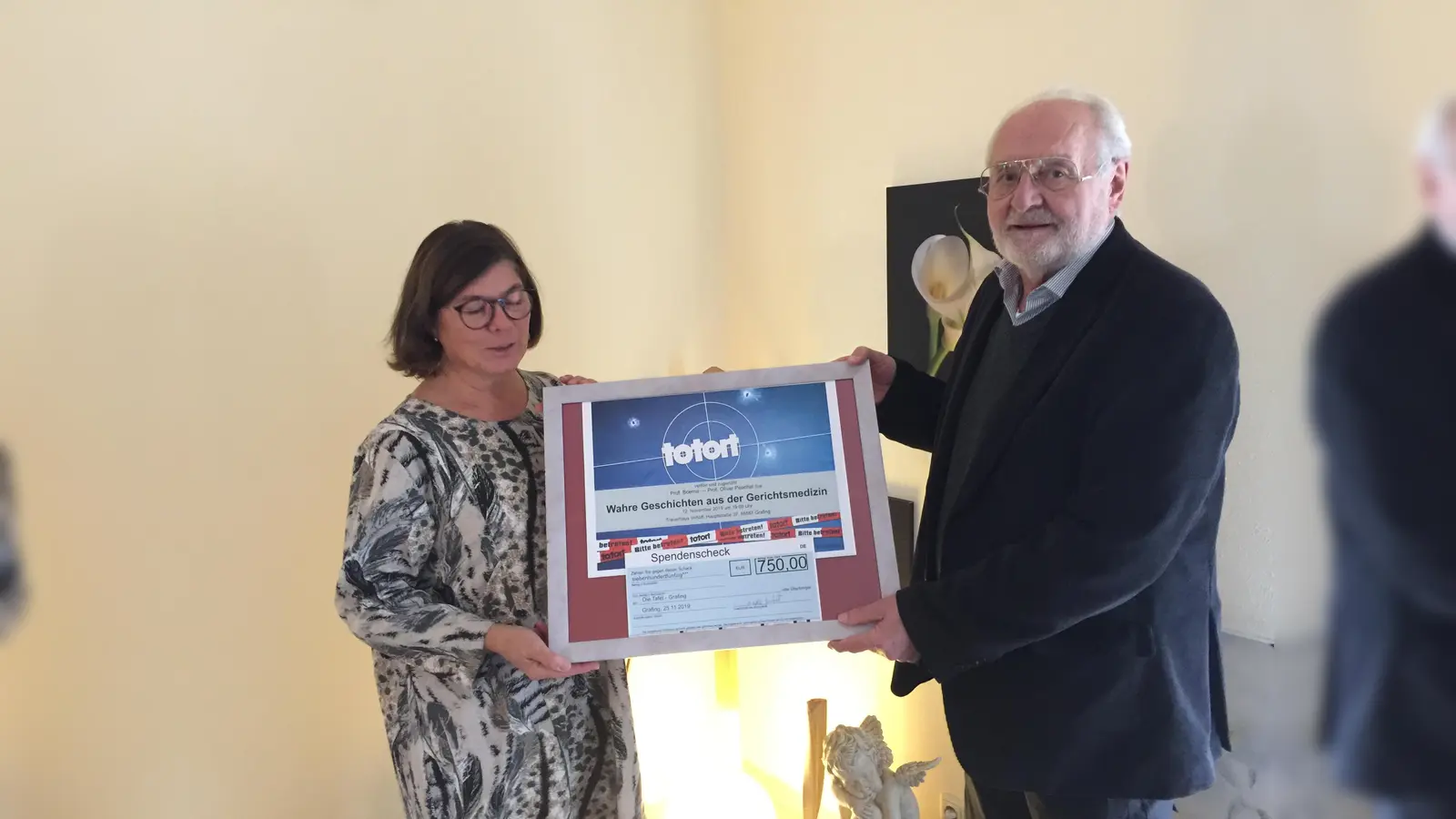 Angela Imhoff übergibt Hans Rombeck einen Spendencheck in Höhe von 750 Euro für die Grafinger Tafel. (Foto: Tafel)