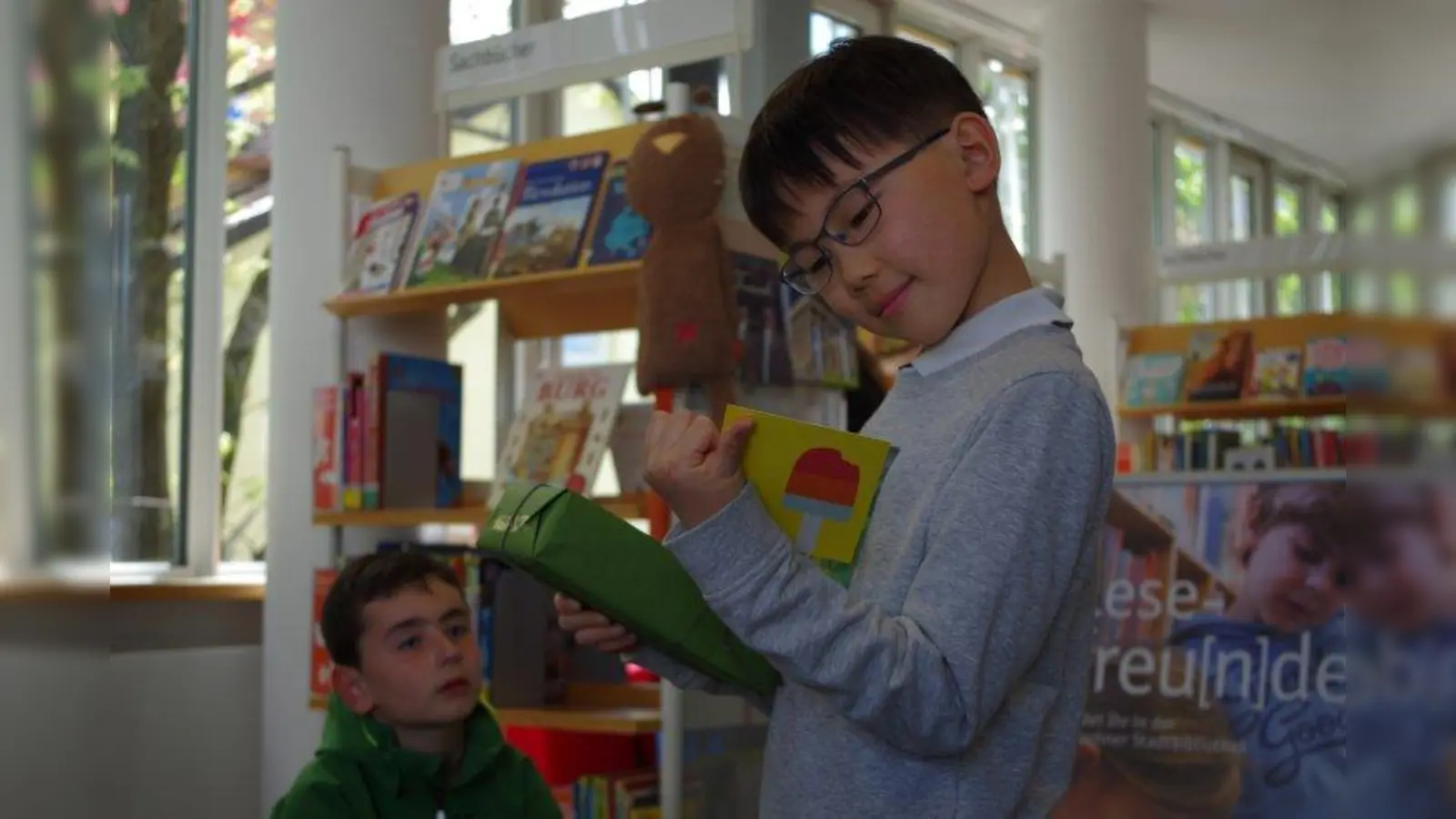 Bücherbegeistert! David hat 200 Vorlesestunden der „Lesefüchse“ in der Laimer Stadtbibliothek besucht. Dafür gab es ein großes Buchgeschenk! (Foto: kö)