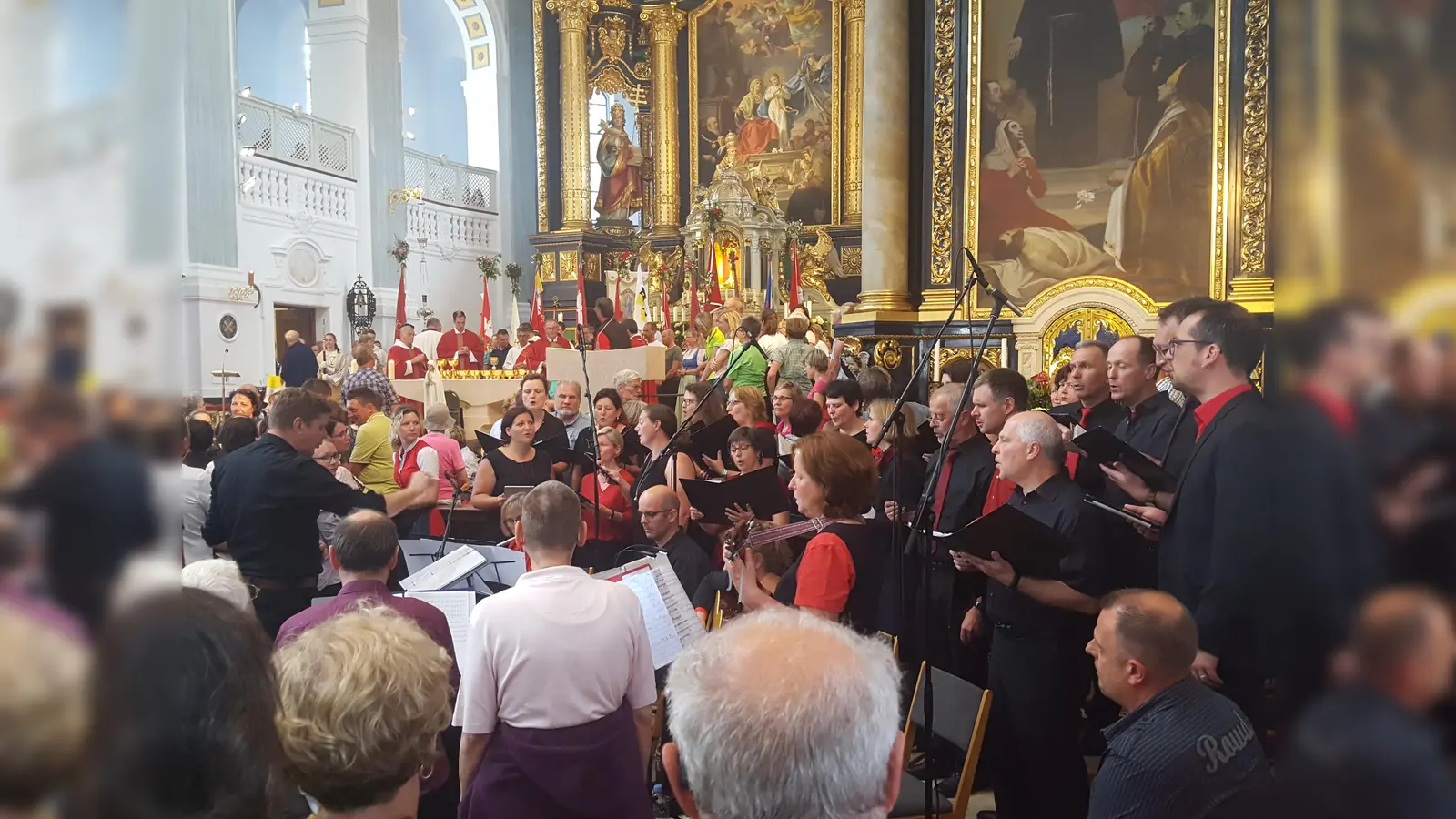 Der „Chor undique“ unter Leitung von Alex Nadler (li) in der St.Anna-Basilika in Altötting. (Foto: Otto Hartl)