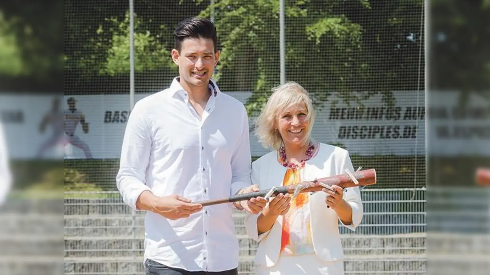 Michael Stephan von den Disciples überreicht den mit Scheinen bestückten Baseballschlägers an Haars Bürgermeisterin Gabriele Müller.	 (Foto: Gemeinde Haar)