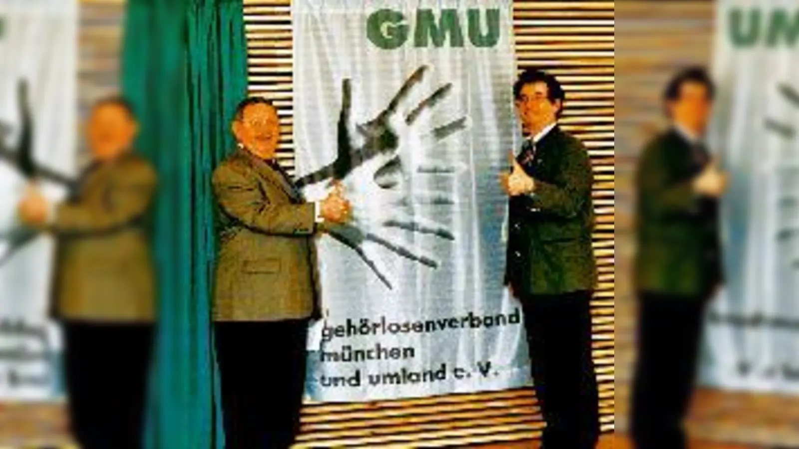 Bundestagsabgeordneter Herbert Frankenhauser und Gehörlosenverbands-Geschäftsführer Rudi Sailer vor der Verbandsfahne im neuen Zentrum.	<br>	 (Foto: Deppisch)