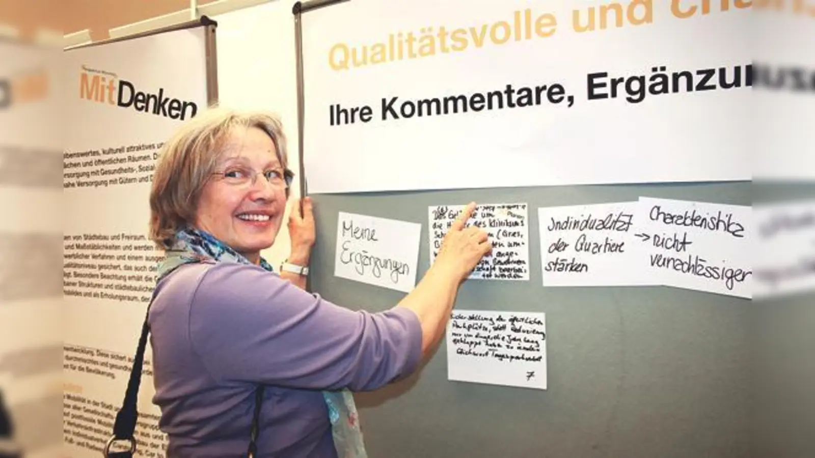 Eine Bürgerin pickt den Zettel mit ihren Wünschen für den Münchner Norden an die Stellwand im Kulturhaus Milbertshofen. 	 (Foto: ws)