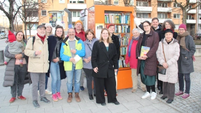 Über den Bücherschrank am Herzog-Ernst-Platz freuen sich Bürger und Mitglieder des Bezirksausschusses mit dessen Vorsitzendem Markus Lutz (Vierter von rechts), Stadträtin Barbara Likus (Siebte von rechts), Bücherschrankpatin Rita Völkel (Achte von links) sowie Christina Zengerle (Fünfte von links) und Julia Achtner (Neunte von links) vom Nachbarschaftstreff Theresia. (Foto: job)