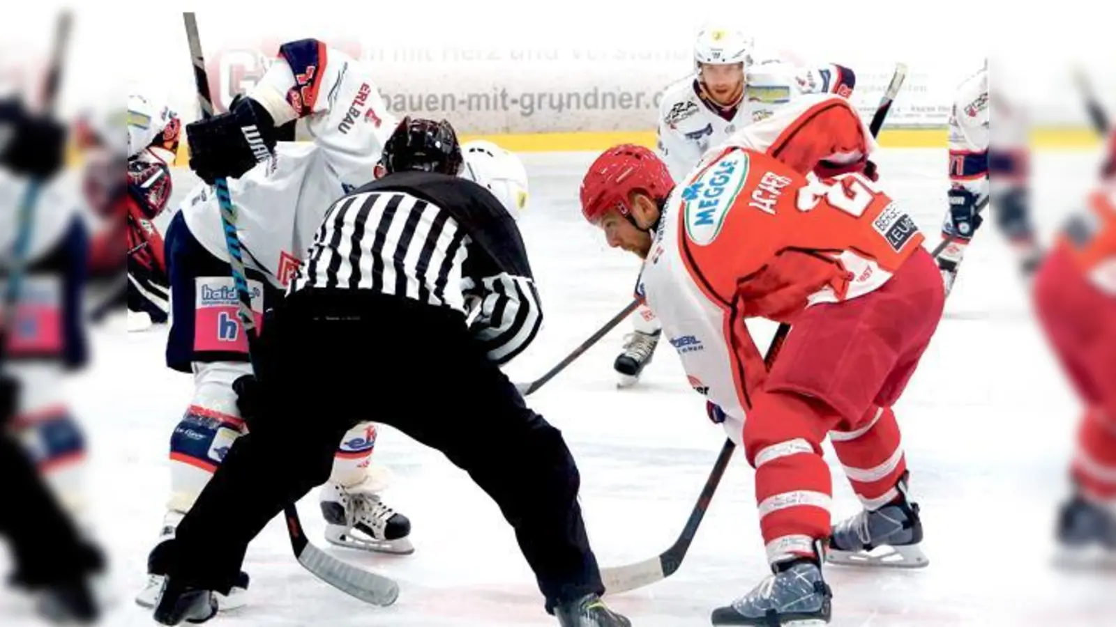 Kapitän Gert Acker vom EHC Klostersee (rotes Trikot) beim Bully im letzten Aufeinandertreffen mit dem Deggendorfer SC, bei dem die Grafinger am Sonntag gastieren.	 (Foto: smg / Chris Unverdorben)