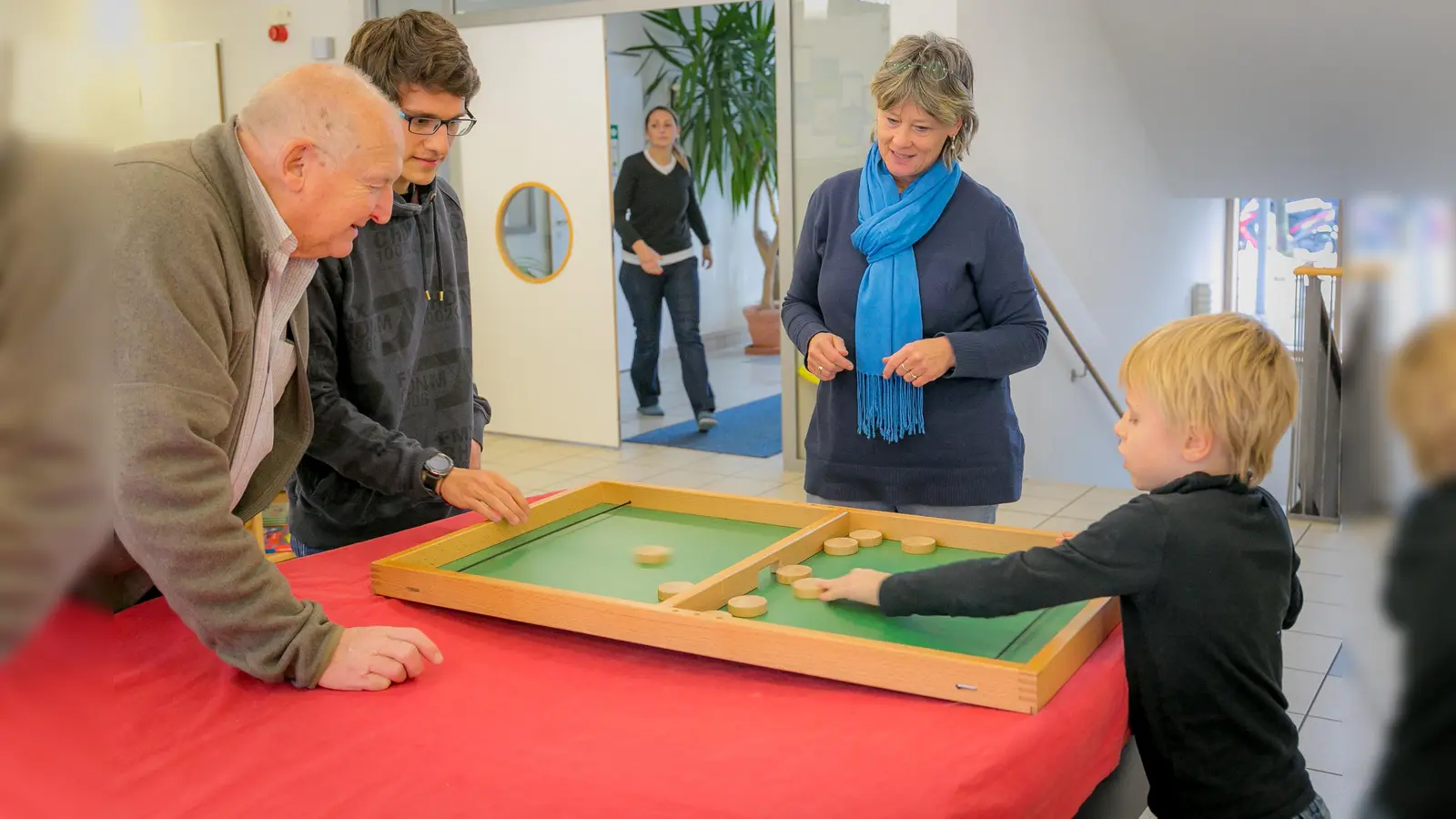 Tom Werneck vom Bayerischen Spielearchiv und die Leiterin des AWO-Horts Claudia Engelmann im Spiel vertieft. (Foto: oh)