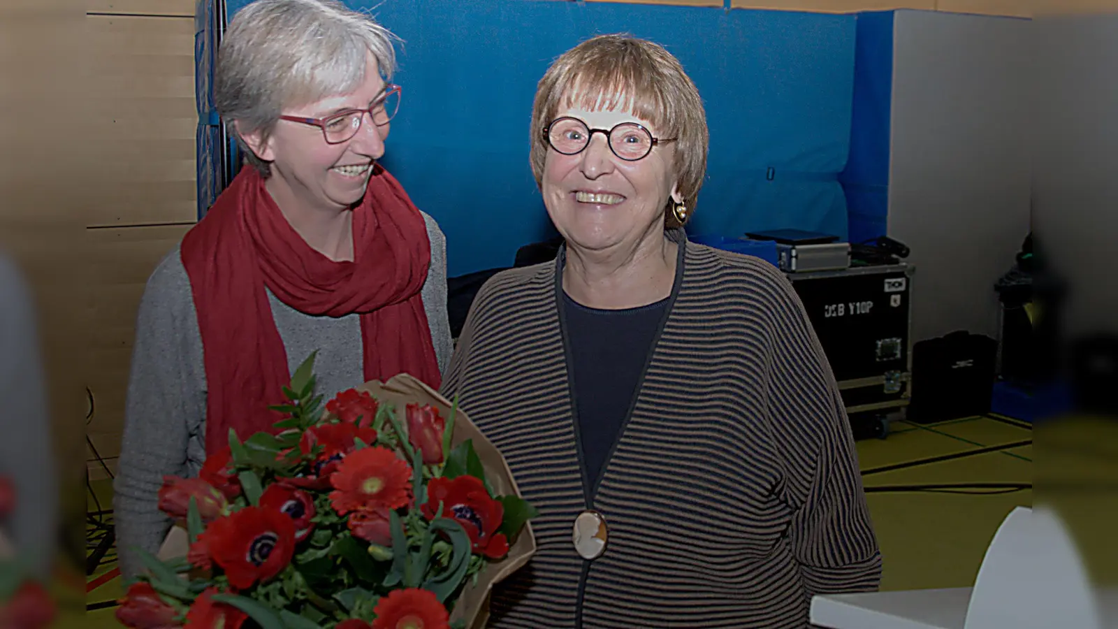 Ein Dankeschön mit Blumenstrauß und warme Worte gab es für die Bezirksausschussvorsitzende Adelheid Dietz-Will (rechts) auf ihrer letzten Bürgerversammlung. Links SPD-Fraktionskollegin Nina Reitz. (Foto: SPD Au-Haidhausen)