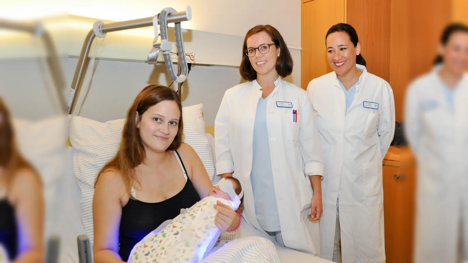 Chefärztin Dr. Helen Budiman und Oberärztin Carla Maier (v. re.) stellen an der kleinen Lena – hier mit Mutter Sabrina – den neuen Schlafsack zur Gelbsucht-Therapie vor. (Foto: kk/sf)